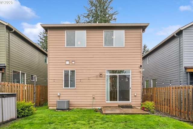 rear view of house with cooling unit, a patio, a fenced backyard, and a lawn