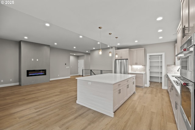 3200 N Abernathy Cir, Ridgefield, WA 98642 - kitchen featuring appliances with stainless steel finishes, a kitchen island, light wood-style flooring, light countertops, and recessed lighting