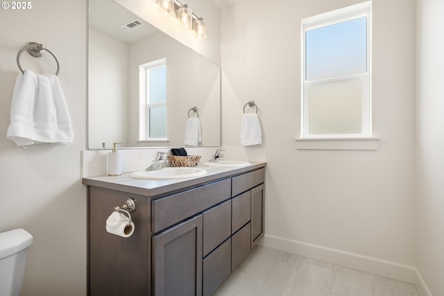 881 E Autumn Ave, Hermiston, OR 97838 - bathroom featuring double vanity, baseboards, and toilet