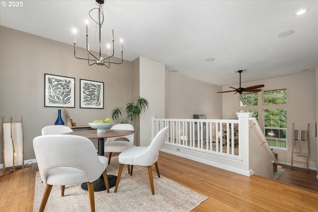 dining area featuring ceiling fan with notable chandelier and light hardwood / wood-style flooring