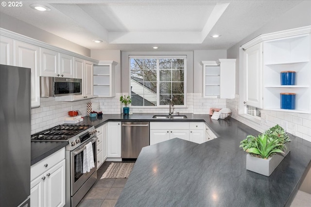 kitchen featuring stainless steel appliances, white cabinetry, a raised ceiling, and sink