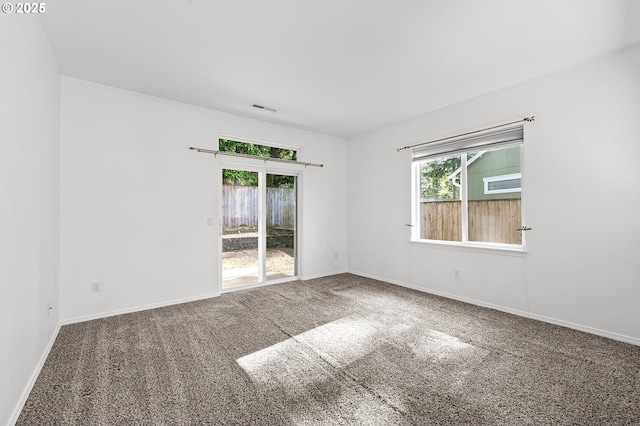unfurnished room featuring plenty of natural light, carpet floors, and baseboards