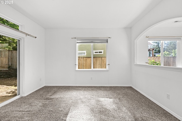 unfurnished room featuring healthy amount of natural light, carpet floors, and baseboards