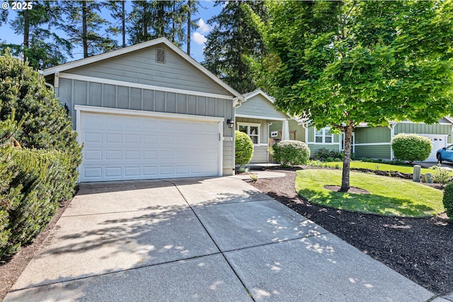 view of front of home featuring board and batten siding, driveway, a front yard, and an attached garage