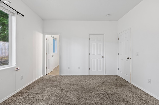 unfurnished bedroom featuring carpet and baseboards