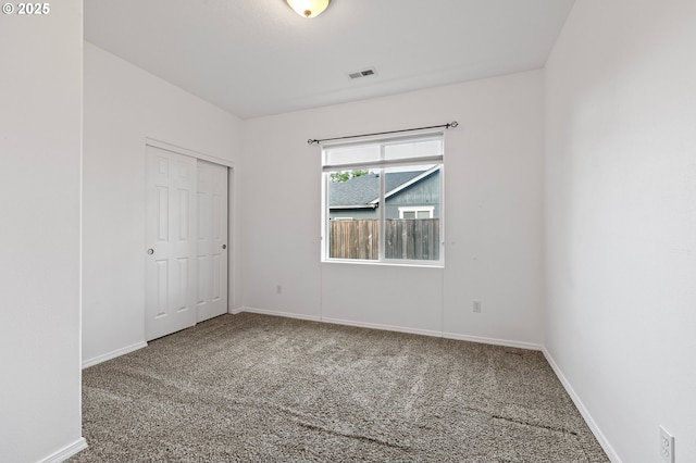 unfurnished bedroom featuring carpet flooring, baseboards, and a closet