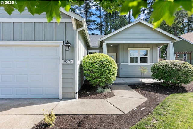 view of front of home with board and batten siding, a garage, concrete driveway, and a shingled roof