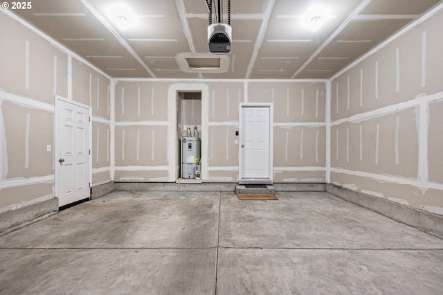 garage with strapped water heater and a garage door opener