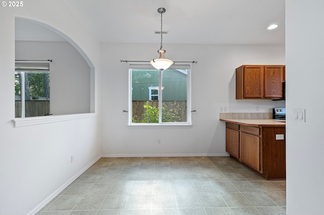unfurnished dining area featuring arched walkways, recessed lighting, and baseboards