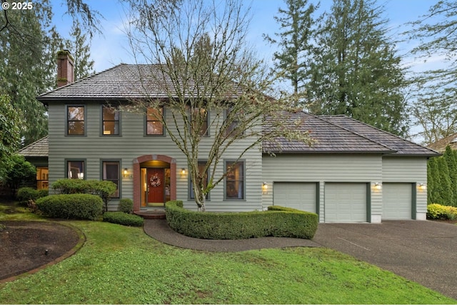 colonial-style house featuring a front yard and a garage