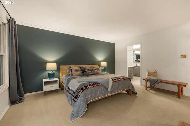 carpeted bedroom featuring ensuite bathroom and crown molding