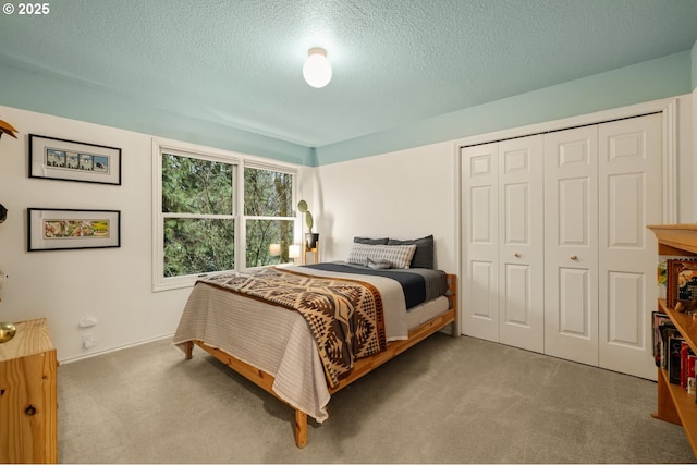 carpeted bedroom featuring a closet and a textured ceiling