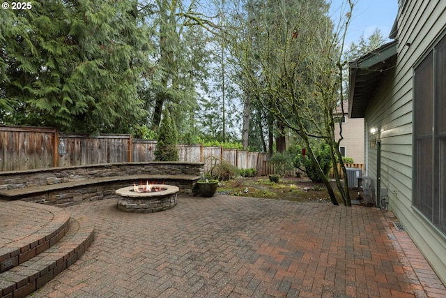 view of patio with an outdoor fire pit and central AC unit