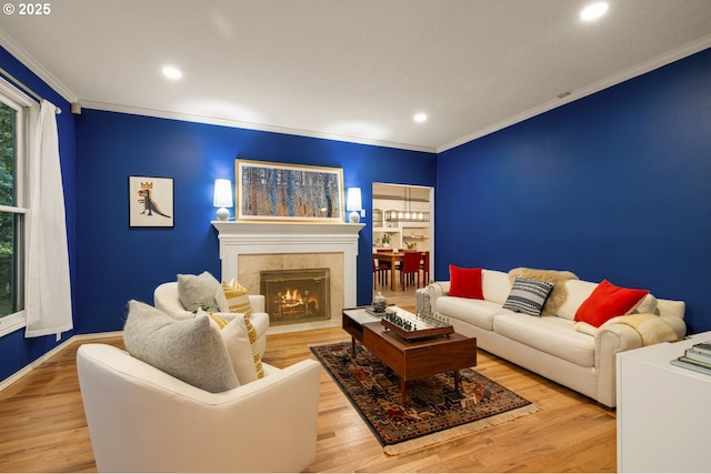 living room featuring a tile fireplace, light wood-type flooring, and crown molding