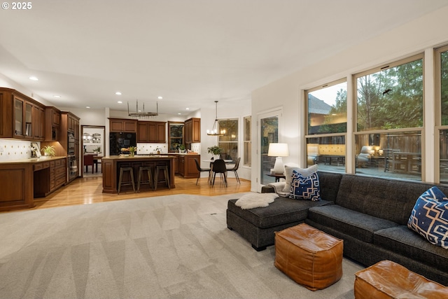 living room featuring a notable chandelier and light hardwood / wood-style flooring