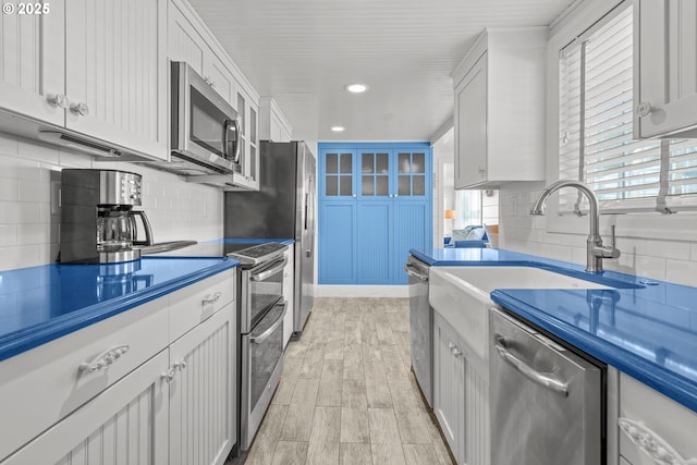 kitchen with tasteful backsplash, appliances with stainless steel finishes, light wood finished floors, and recessed lighting