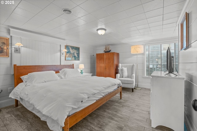 bedroom featuring visible vents and wood finished floors