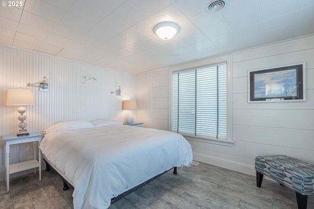bedroom featuring wood finished floors, baseboards, and visible vents