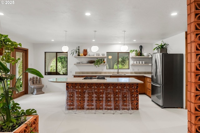 kitchen with open shelves, freestanding refrigerator, recessed lighting, light countertops, and a sink