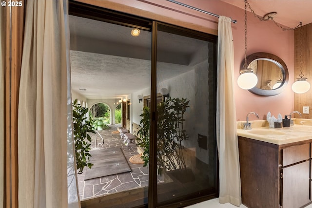 interior space featuring vanity and a textured ceiling