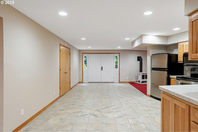 7678 Pine Tree Ln SE, Turner, OR 97392 - kitchen with appliances with stainless steel finishes, tile counters, baseboards, recessed lighting, and a wood stove