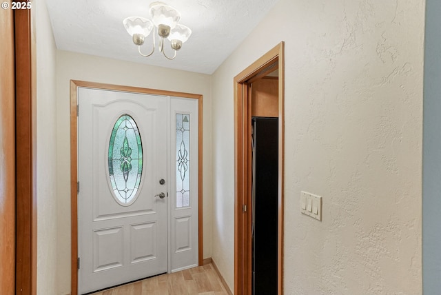 7678 Pine Tree Ln SE, Turner, OR 97392 - foyer entrance with a chandelier, light wood-style flooring, baseboards, and a textured wall