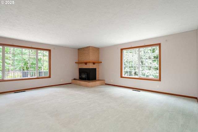 7678 Pine Tree Ln SE, Turner, OR 97392 - unfurnished living room with healthy amount of natural light, baseboards, carpet, a brick fireplace, and a textured ceiling