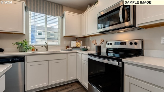 kitchen featuring stainless steel appliances, a sink, and light countertops