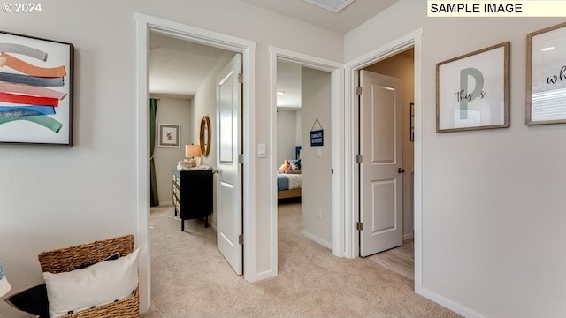 hallway with light carpet and baseboards