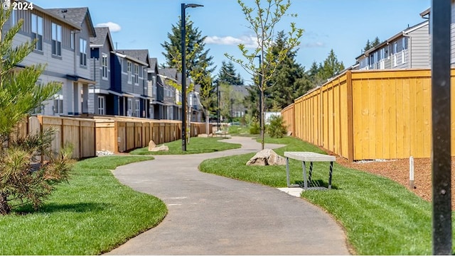 view of home's community with a yard, a residential view, and fence