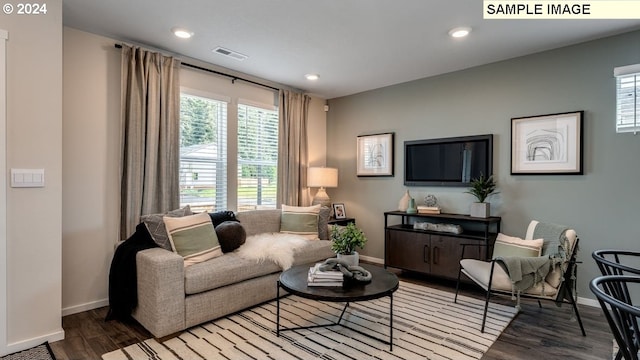 living area featuring baseboards, visible vents, wood finished floors, and recessed lighting