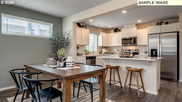 kitchen featuring appliances with stainless steel finishes, white cabinetry, and dark wood-style floors