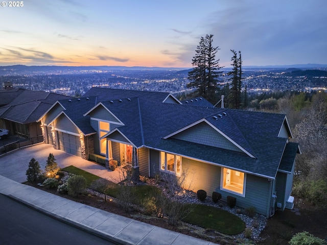 craftsman-style house with driveway, roof with shingles, and a garage