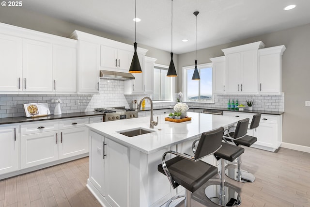 10397 SE Quail Ridge Dr, Happy Valley, OR 97086 - kitchen with under cabinet range hood, recessed lighting, light wood-style flooring, white cabinets, and pendant lighting