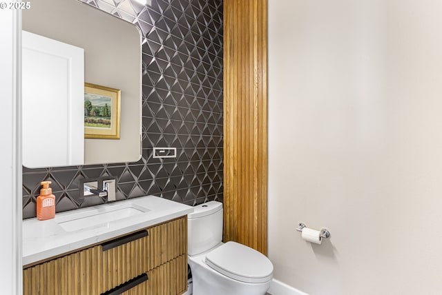 bathroom with vanity, toilet, and baseboards