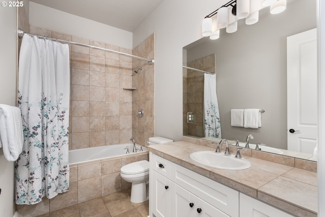 bathroom with vanity, tiled shower / bath, and toilet