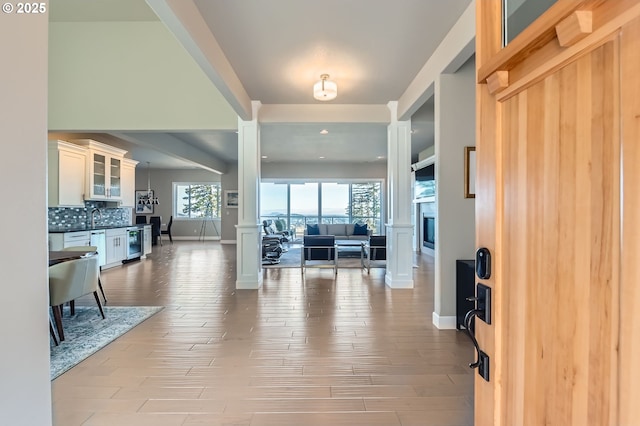 foyer with wood finished floors, baseboards, a fireplace, and recessed lighting