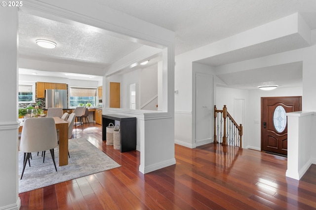 dining space featuring a textured ceiling and dark hardwood / wood-style flooring