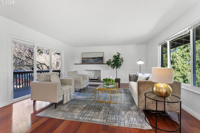 living room featuring dark hardwood / wood-style flooring and a brick fireplace