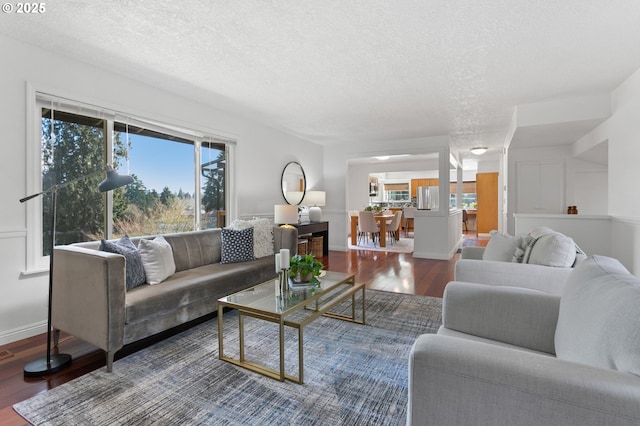 living room featuring dark hardwood / wood-style flooring and a textured ceiling