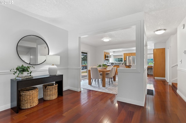 dining area featuring dark wood-type flooring and a textured ceiling