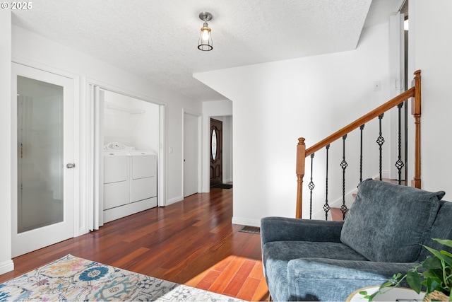 sitting room featuring dark wood-type flooring, washing machine and clothes dryer, and a textured ceiling