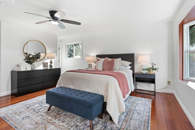 bedroom featuring ceiling fan, wood-type flooring, and a textured ceiling