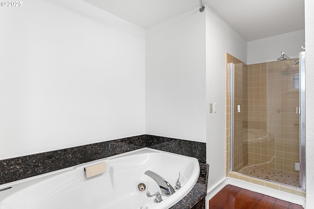 bathroom with independent shower and bath and hardwood / wood-style floors