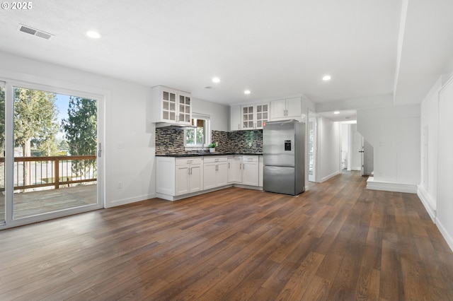 kitchen featuring stainless steel refrigerator with ice dispenser, dark wood-type flooring, tasteful backsplash, and white cabinets