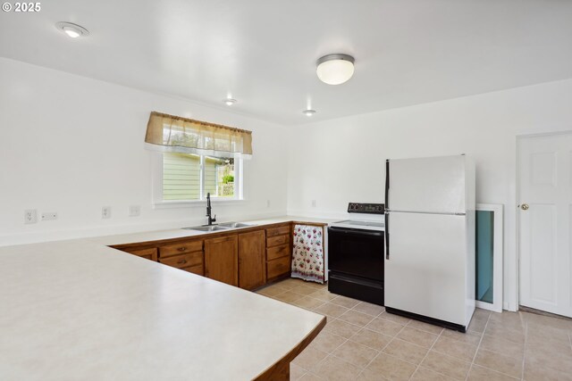 400 Mccoy St, Moro, OR 97039 - kitchen featuring a sink, light countertops, brown cabinetry, electric stove, and freestanding refrigerator