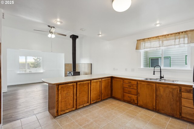 400 Mccoy St, Moro, OR 97039 - kitchen with brown cabinets, a sink, a wood stove, light countertops, and a peninsula
