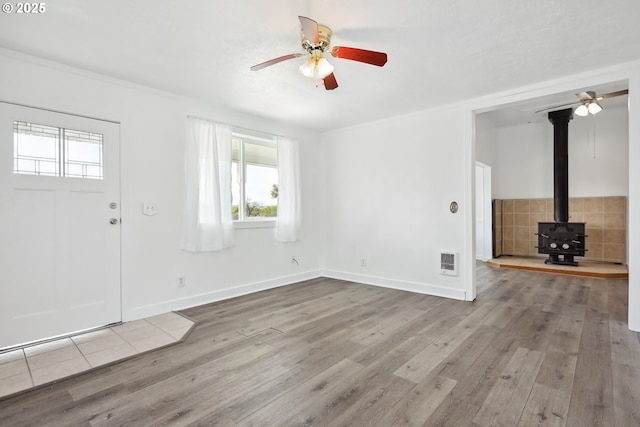 400 Mccoy St, Moro, OR 97039 - unfurnished living room featuring crown molding, a wood stove, wood finished floors, baseboards, and ceiling fan