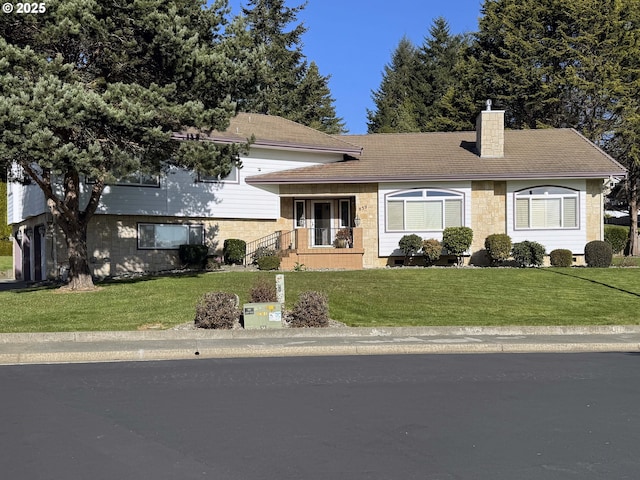 tri-level home featuring covered porch and a front lawn