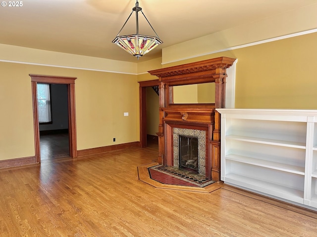 812 SW Saint Clair Ave Unit 3, Portland, OR 97205 - unfurnished living room featuring a fireplace with raised hearth, wood finished floors, and baseboards
